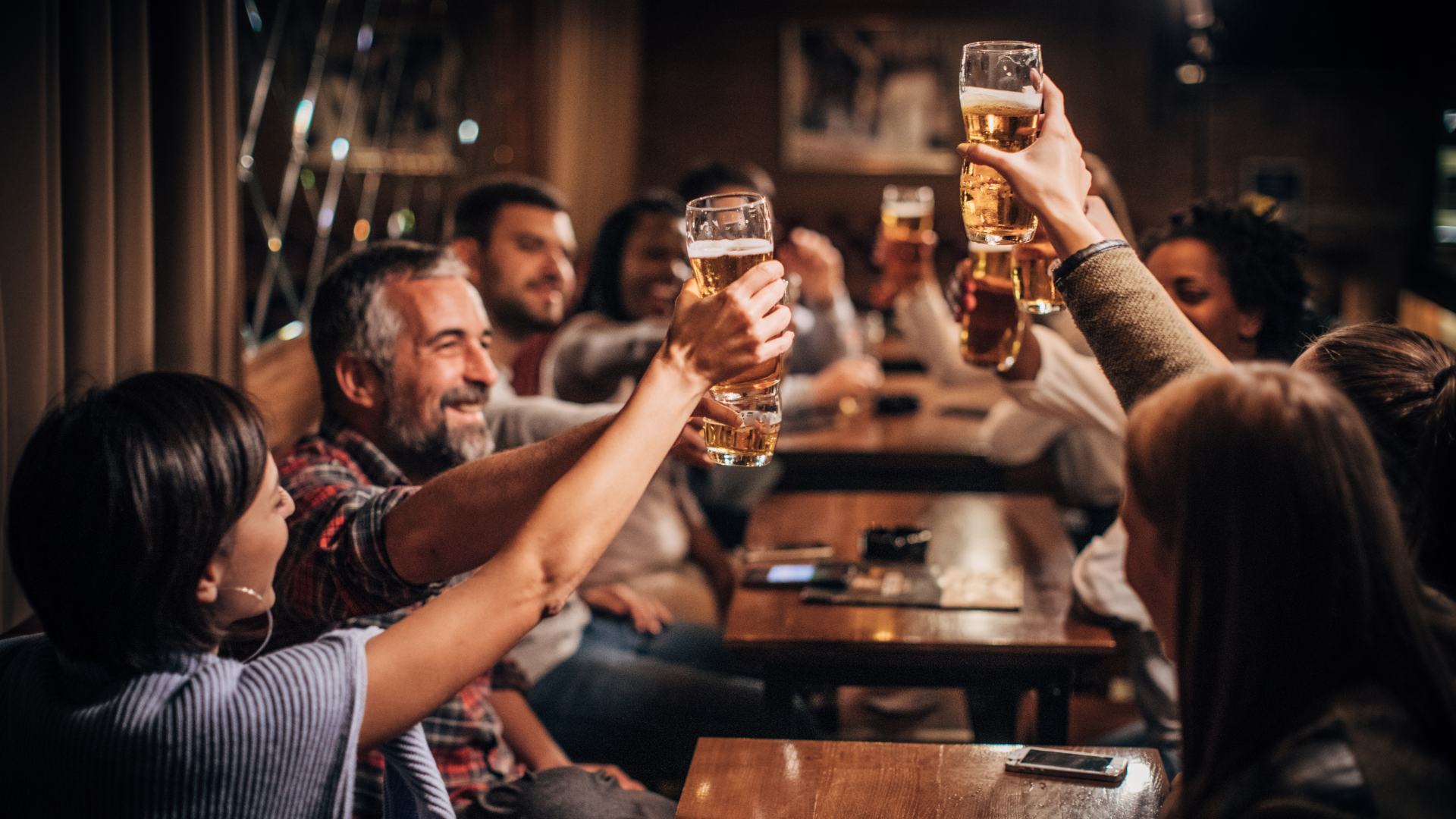 several friends raising a toast at a pub