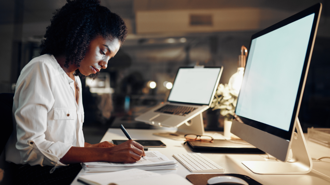 An office manager at a desk, dealing with paperwork