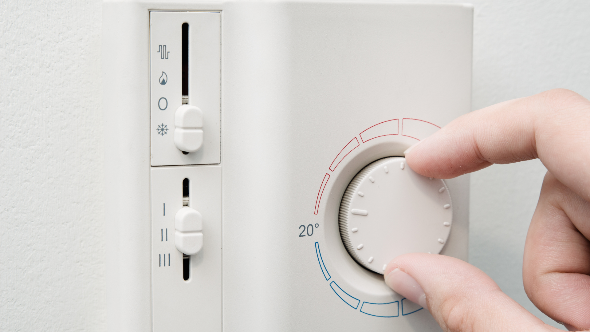 A person turning down a thermostat