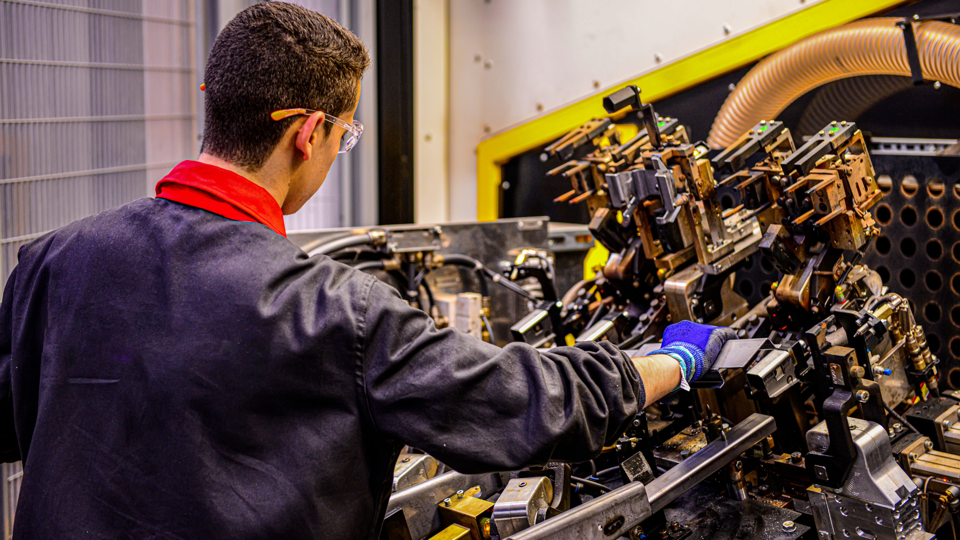 A man in safety glasses using a production machine