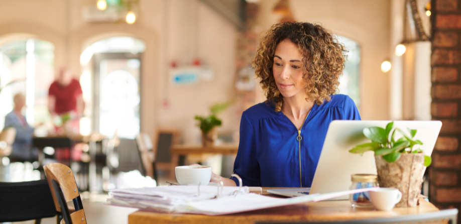 A woman working remotely from a coffee shop