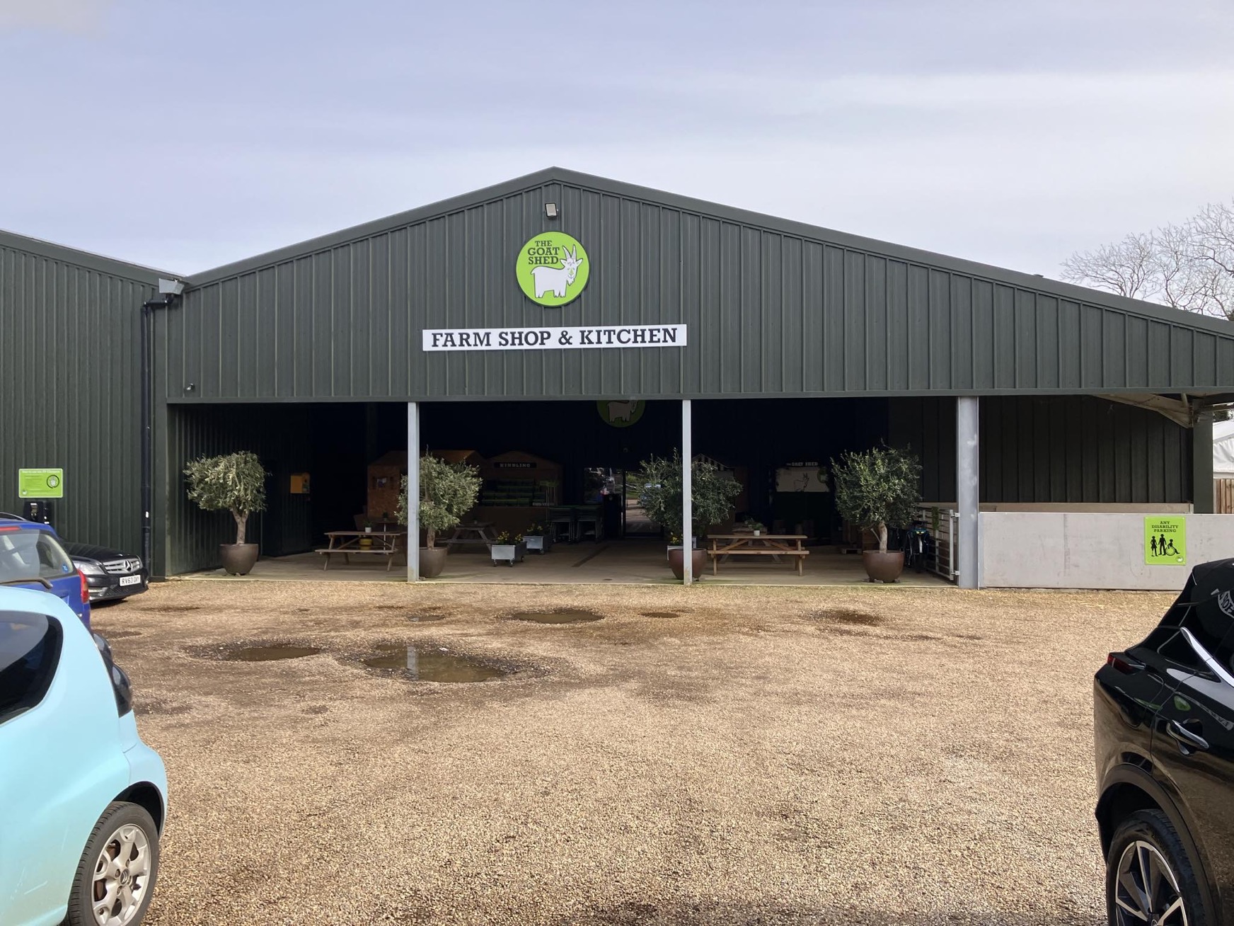 A wide shot of the Goat Shed farm shop, showing the main entrance and the car park