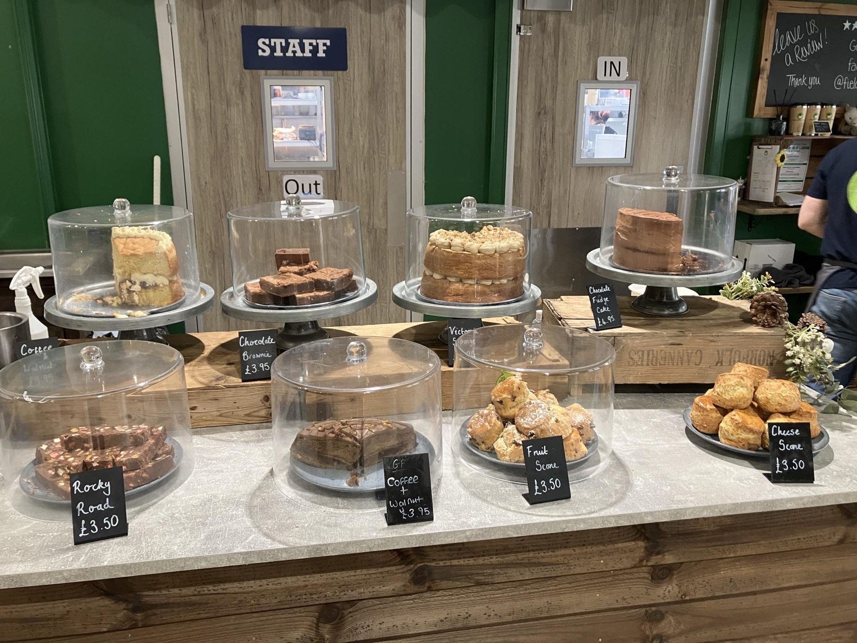 A selection of cakes and sweet baked goods for sale, sitting under glass covers