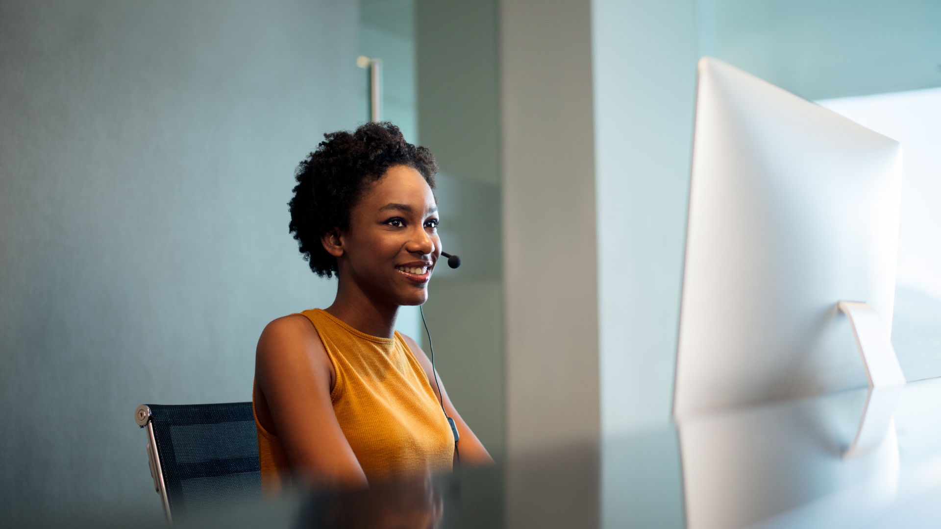 A woman working on a reception desk, wearing a headset