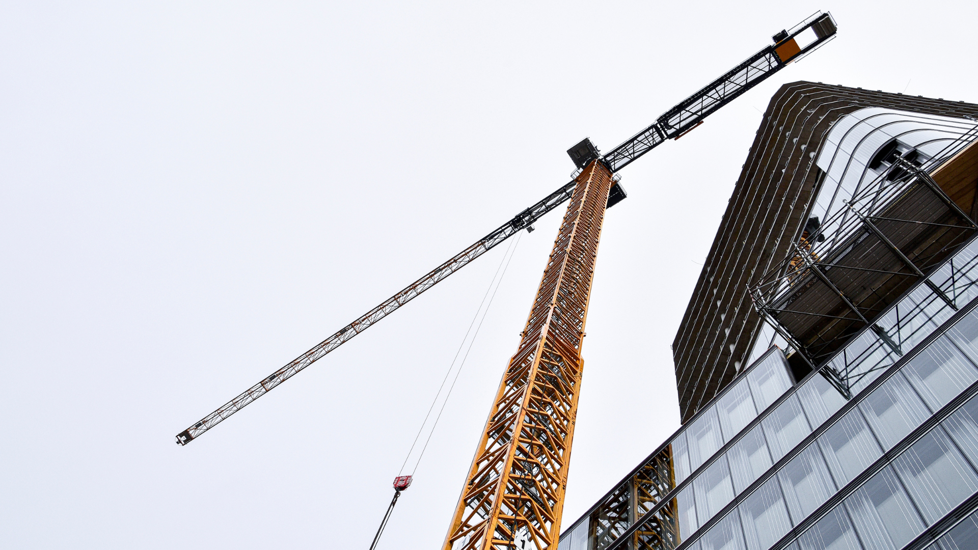 A crane on a construction site viewed from an upwards angle