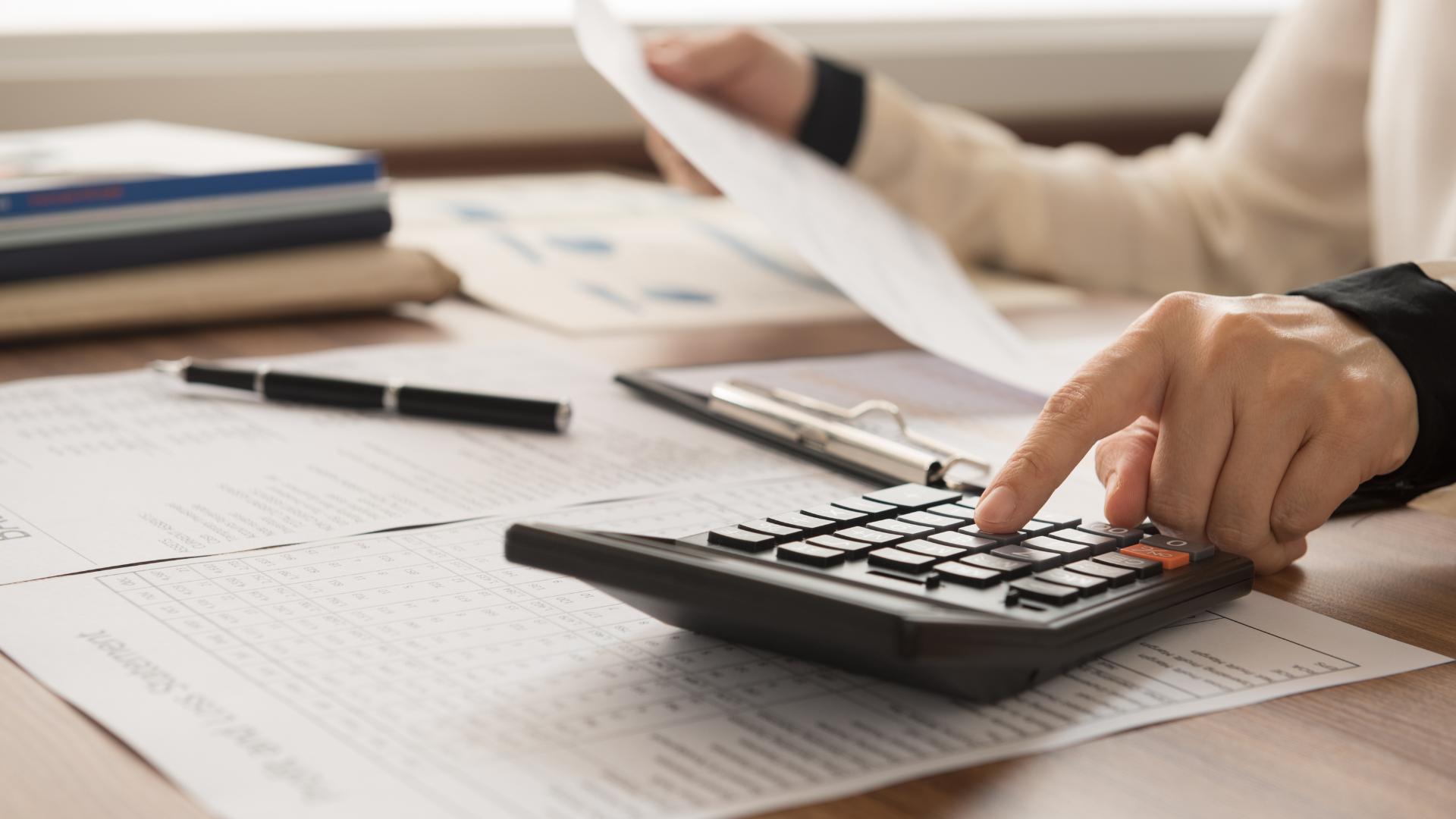 Accountancy documents on a desk with a calculator, being used by an accountant