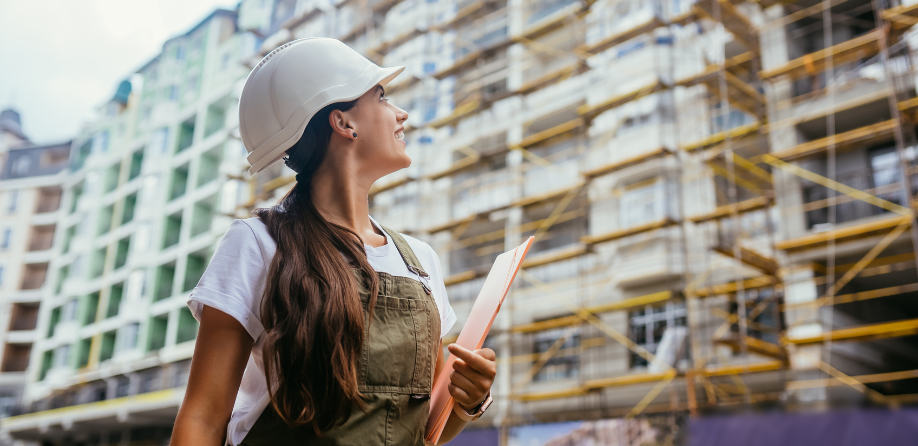 A female construction worker looking at a building site