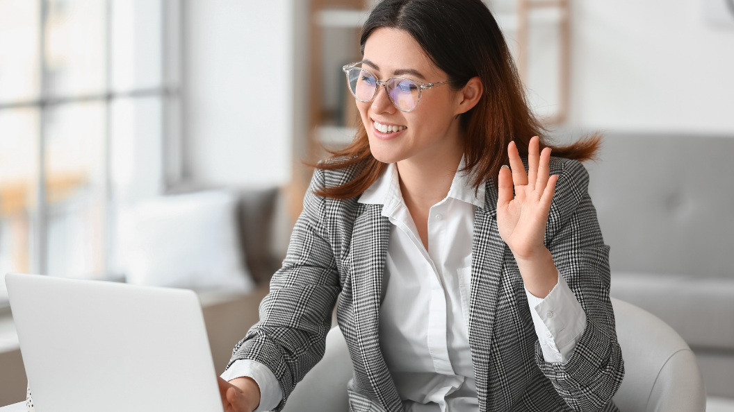 An image of a woman having a remote job interview. She is dressed smartly and is using a laptop.