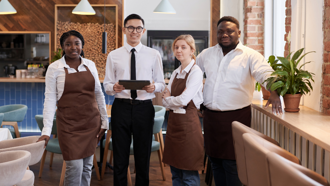 An image of four restaurant workers standing ready before a shift