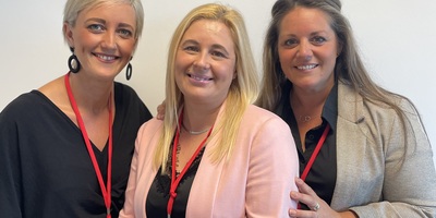 Three Select Lowestoft employees, gathered wearing business attire and red lanyards