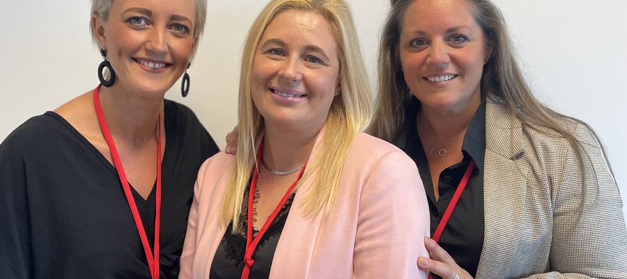 Three Select Lowestoft employees, gathered wearing business attire and red lanyards