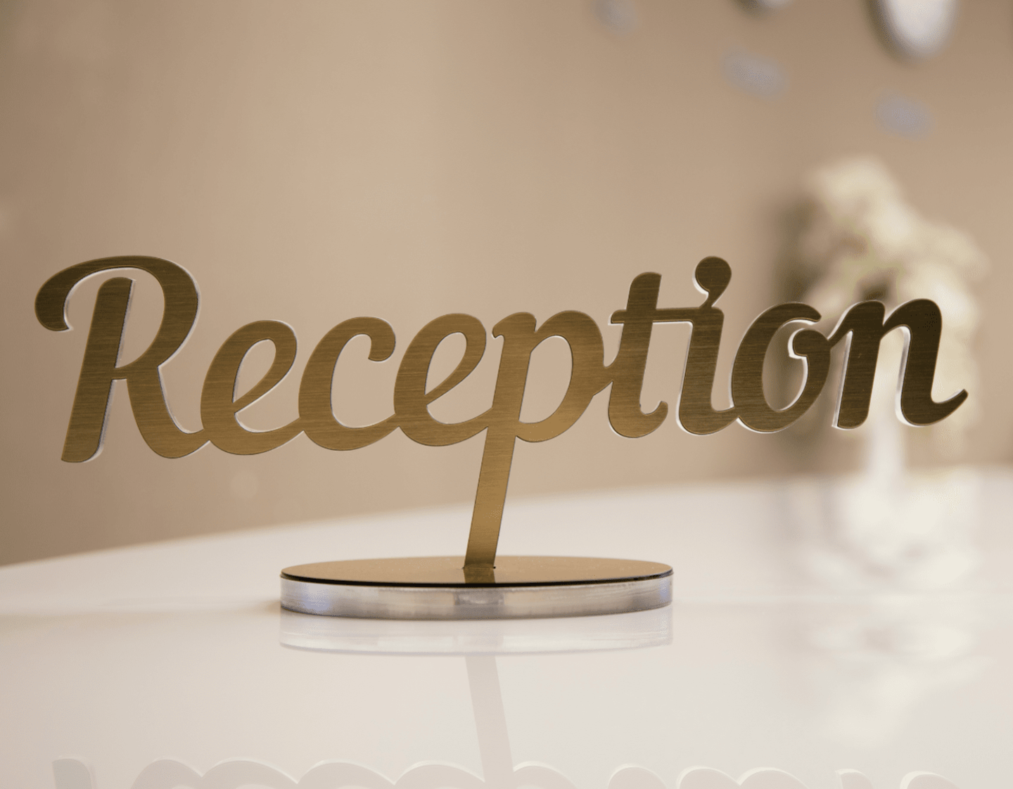 A metal reception sign on a desk
