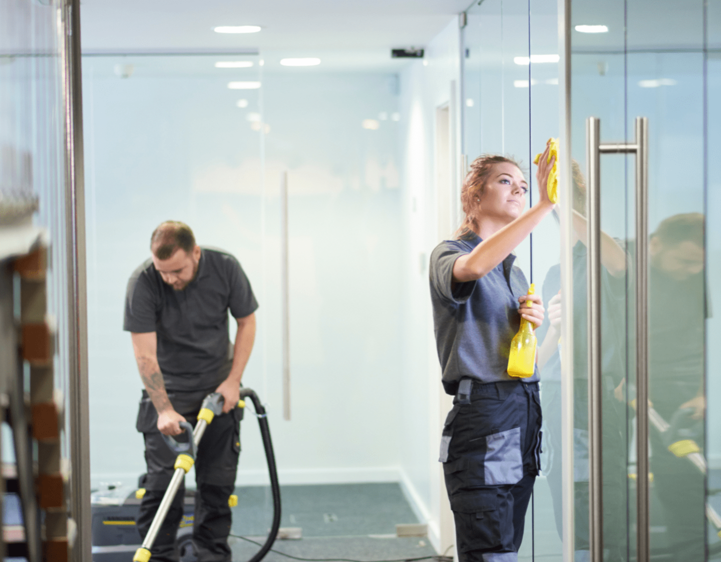 A man and a woman cleaning an office building