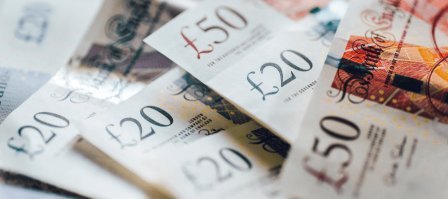 A close-up image of various British bank notes, including 20 pounds and 50 pounds notes