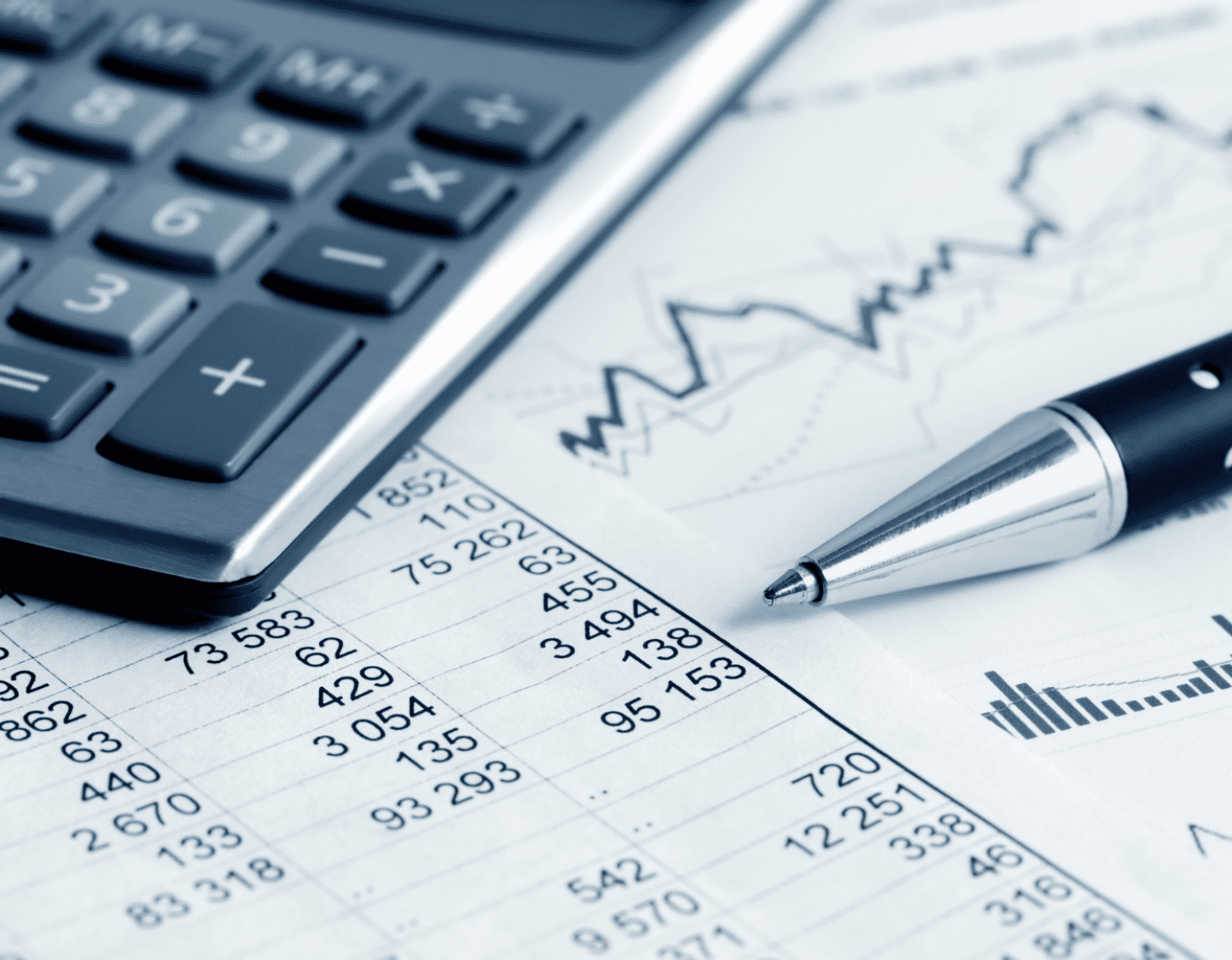 A close-up of a calculator and a pen on a financial information document