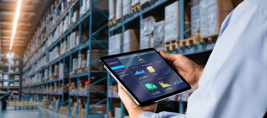 An image of a warehouse worker looking at data on a tablet in a warehouse.